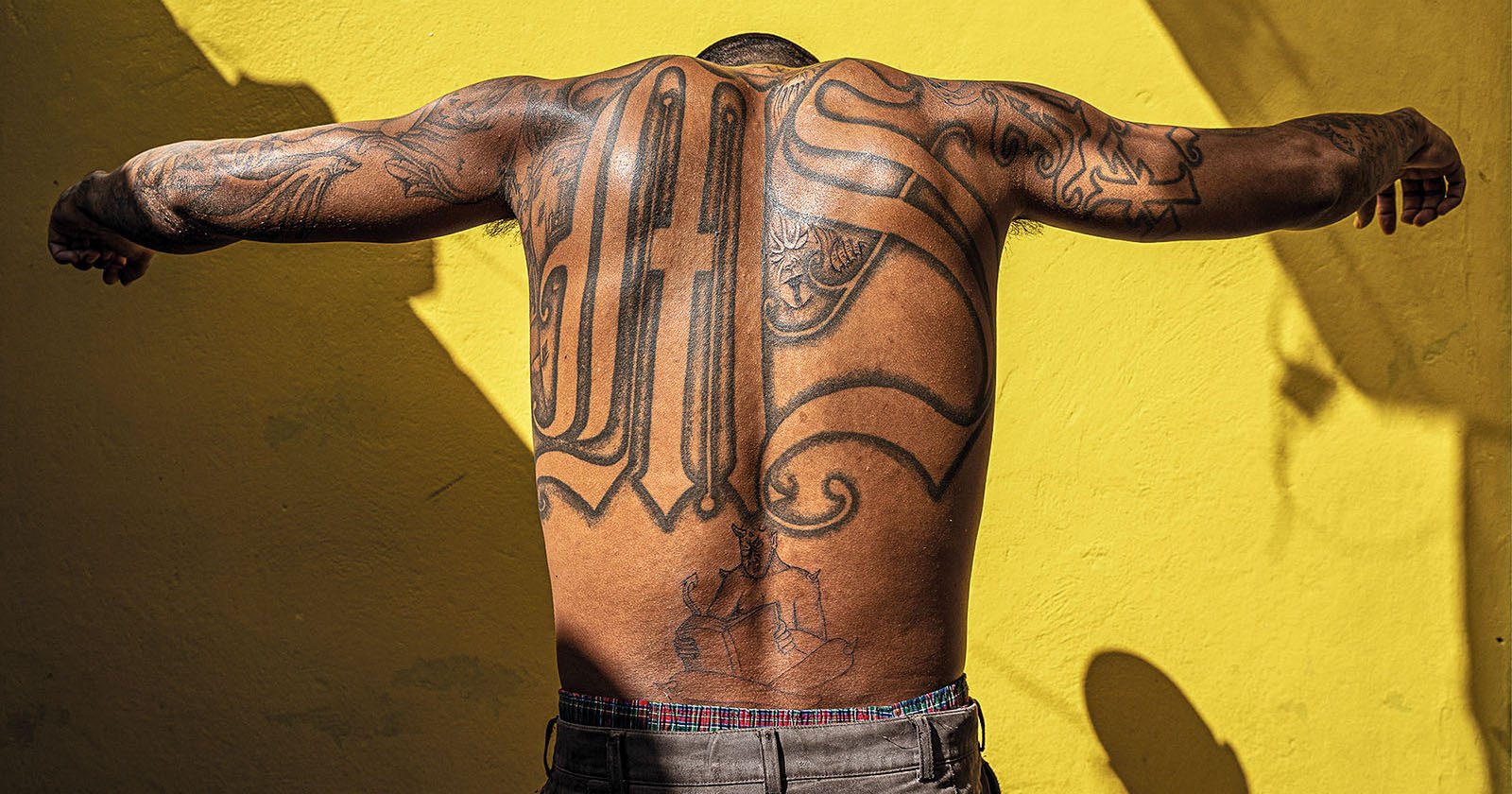 MS gang member showing his tattoo on his back.