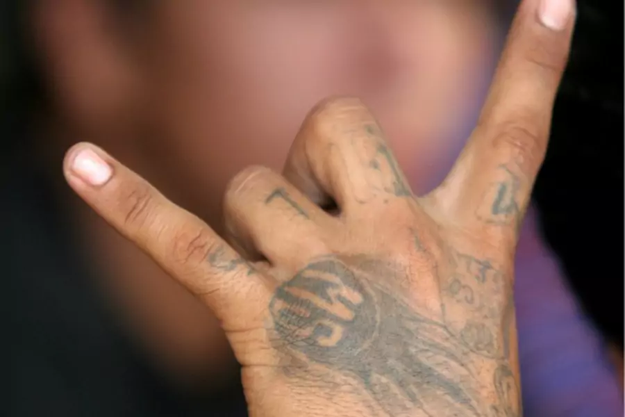 Showing Devil horns sign by tatted hand