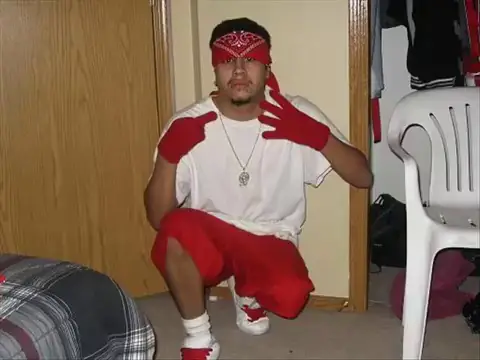 a gang member throwing 14 sign in half kneeling position
