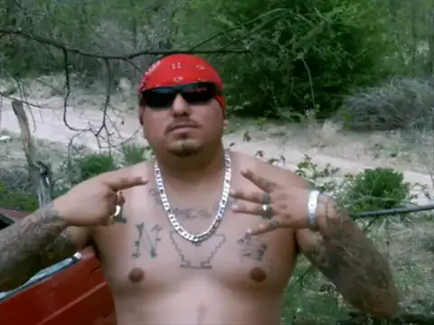 a tatted norteno member showing 14 sign
