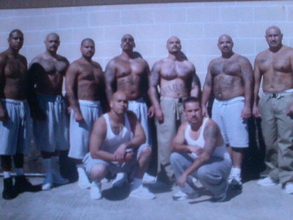 Set of Surenos gang members in front of a wall